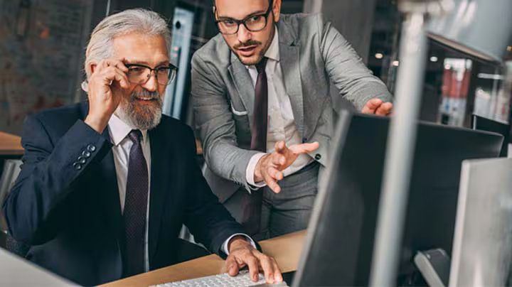 Two businesspeople looking at information on a computer